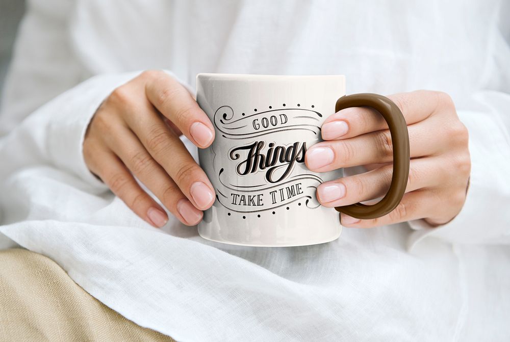 Hand holding coffee mug, good things take time quote