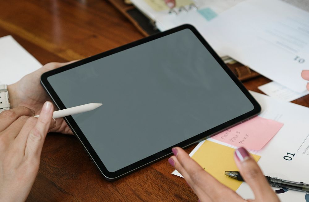 Business person using a wireless stylus with a digital tablet in a meeting