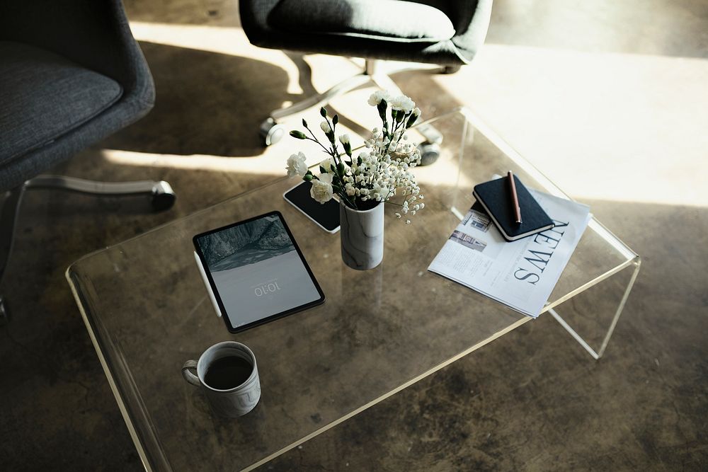 Digital tablet by a vase with white carnation flowers