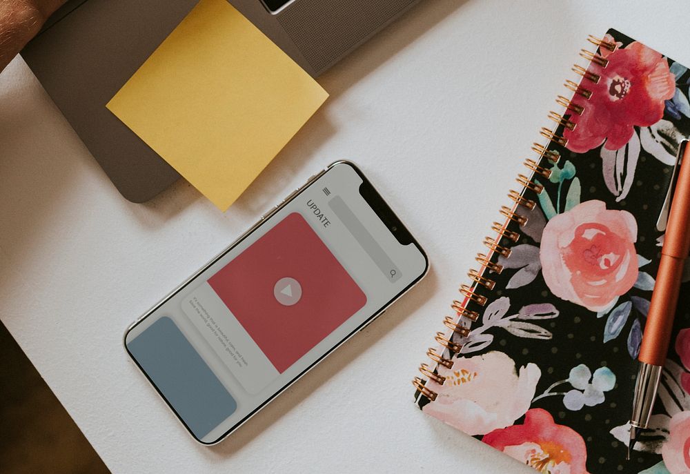 Mobile phone screen by a floral book