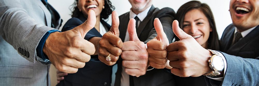Businesspeople doing a thumbs up together