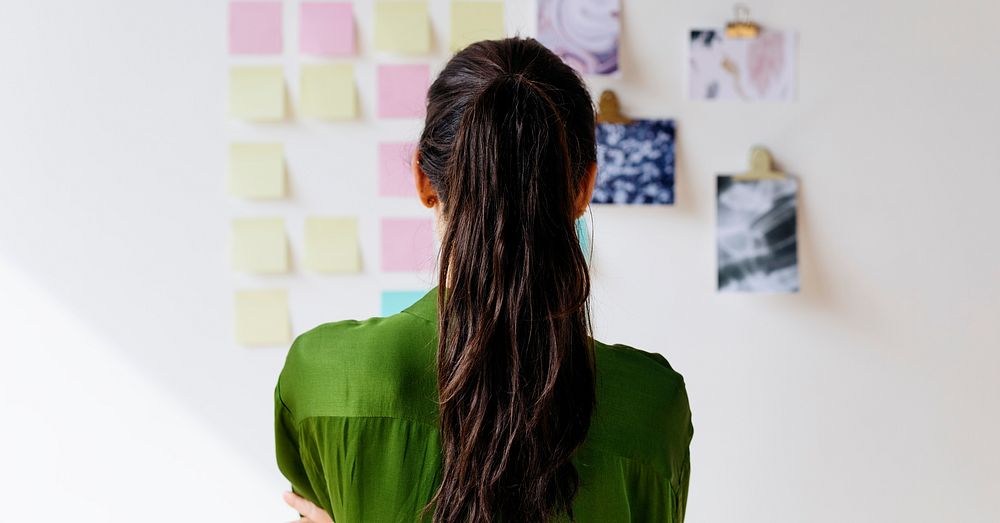 Creative woman with business plans on the wall