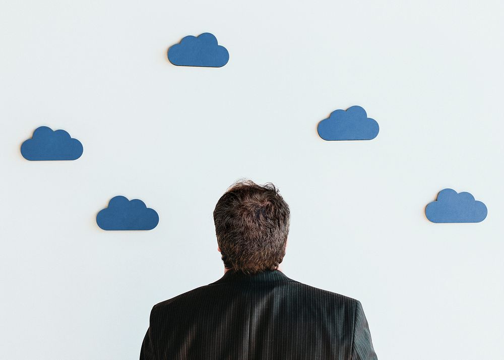 Man looking up to blue cloud icons