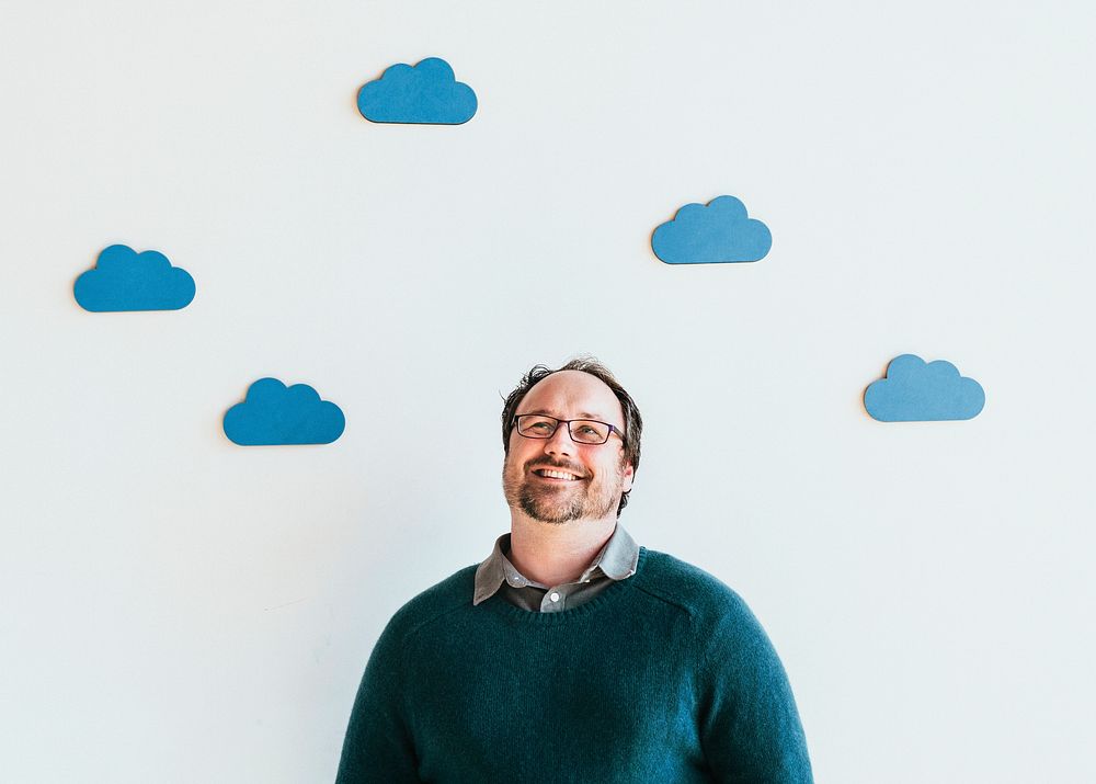 Man looking up to blue cloud icons