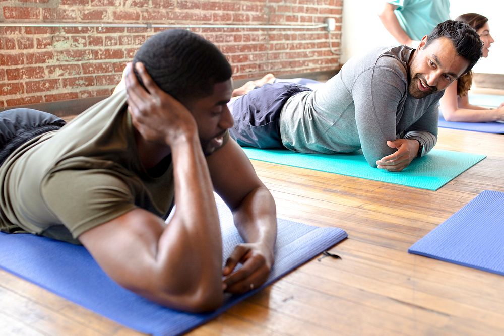 Sportive men relaxing on yoga mats