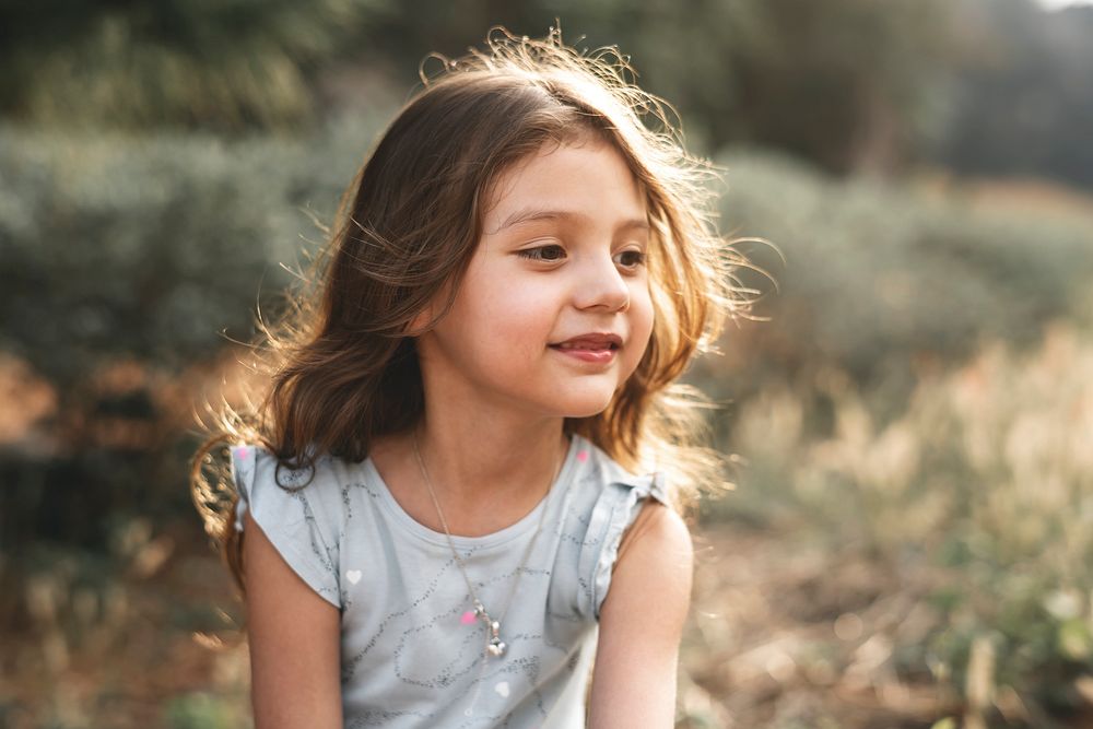 Cheerful little girl smiling in the summer sun