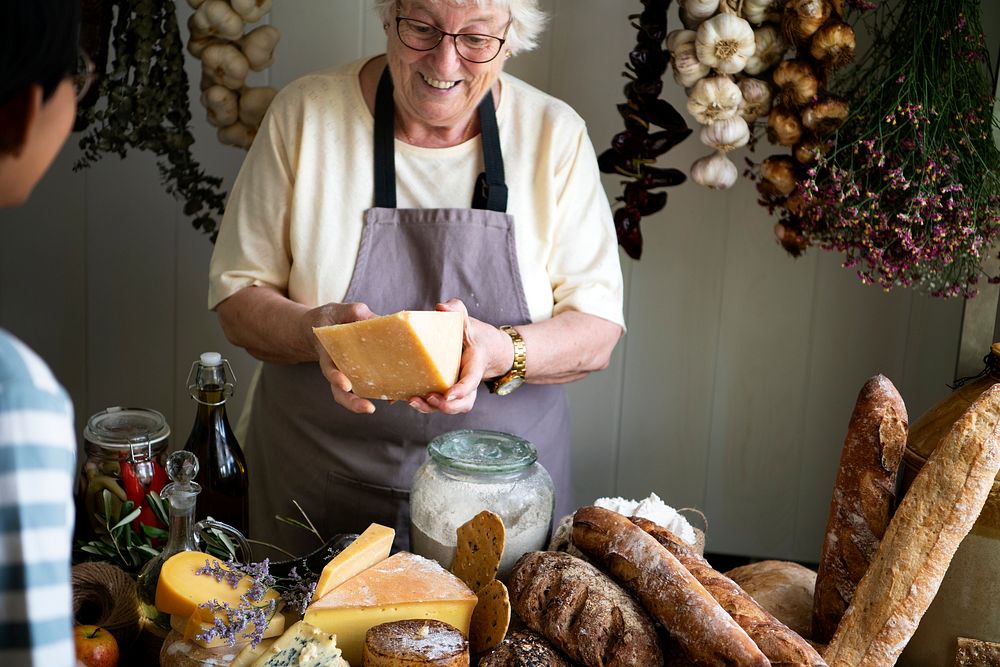 Mature woman selling cheese at a deli