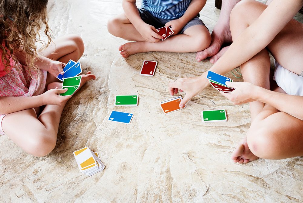 Kids playing cards on the floor