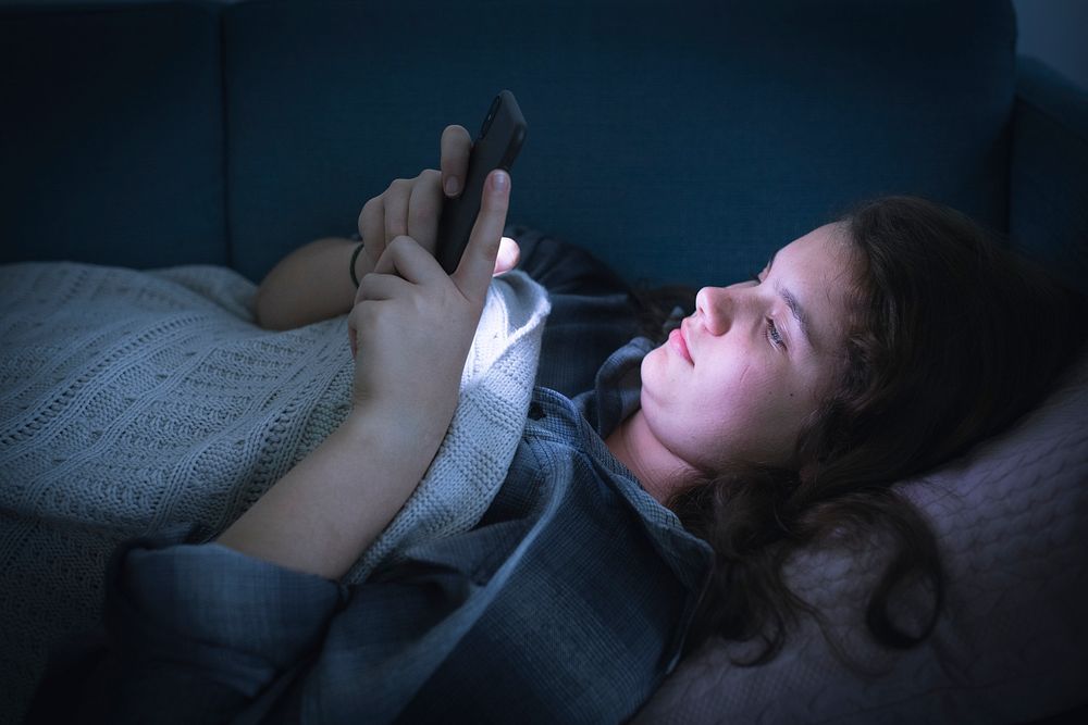 Teen girl texting in the middle of the night