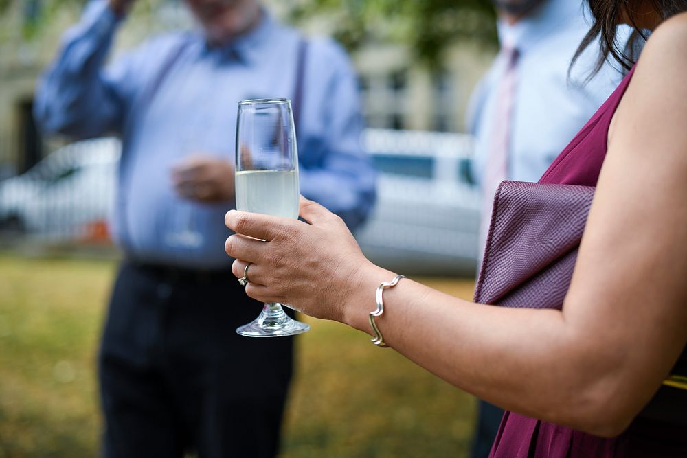 Woman drinking a glass of Champagne at an outdoor party