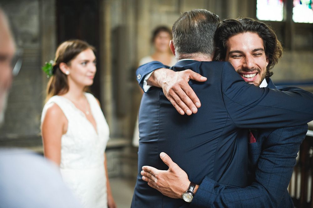 Groom and father of the bride hugging it out