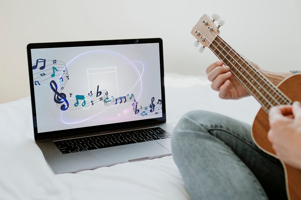 Woman using a laptop screen mockup while playing ukulele during quarantine 