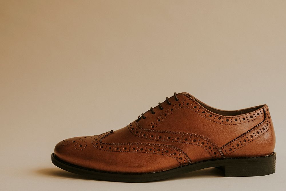 Men's brown leather derby shoes on beige