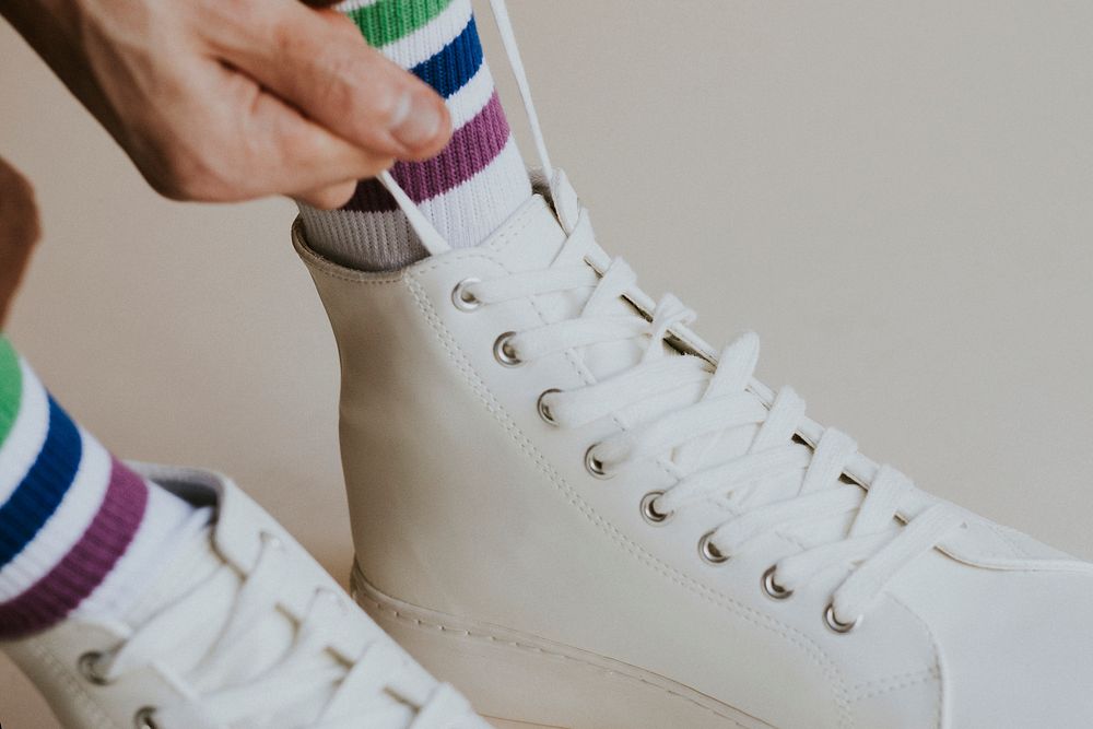 Man tying shoelaces white high top sneaker