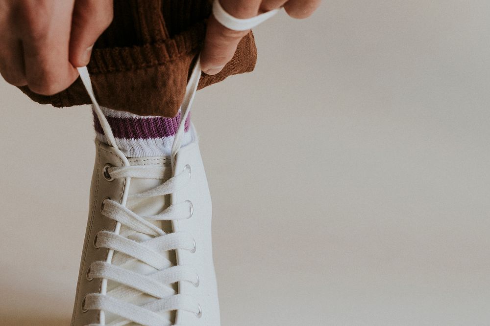 Model hands tying shoelaces white sneaker