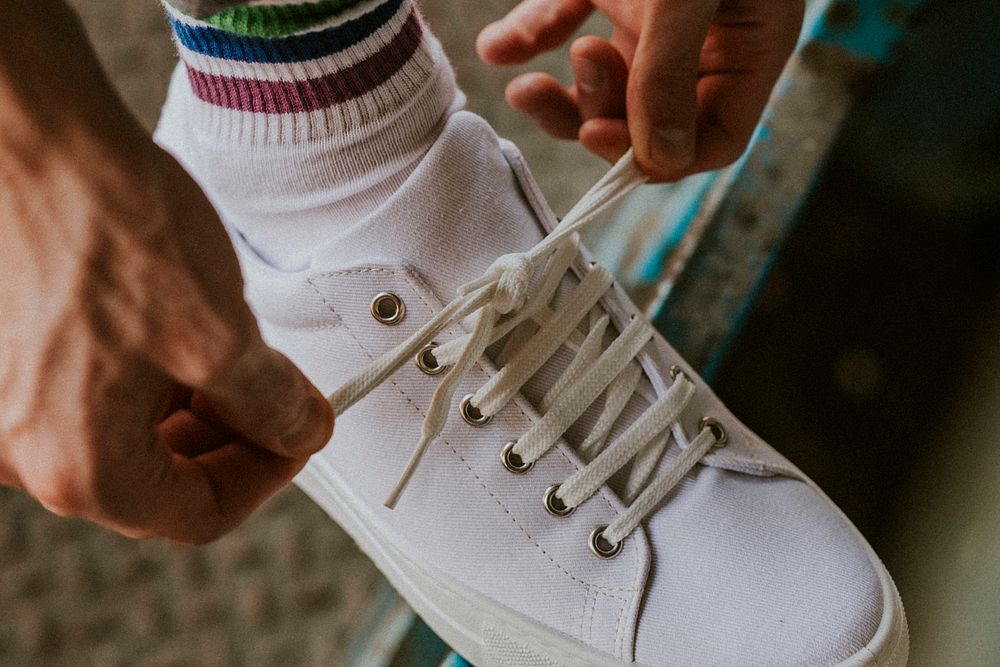 Man tying shoelaces on canvas sneaker