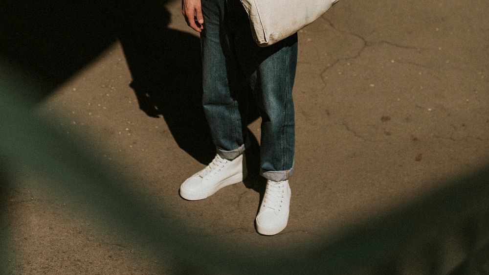 Men's blue jeans with white top sneakers dark tone