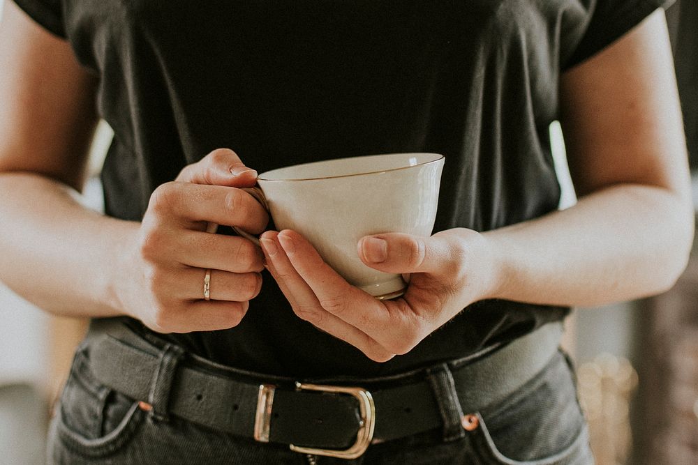 Woman with a tea cup mockup in her hands psd