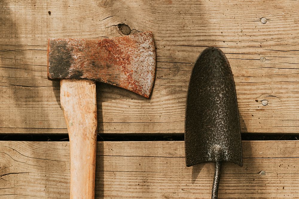 Rustic axe by trowel flatlay on a wooden background