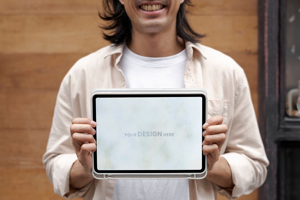 Japanese designer showing a design on digital tablet outside his shop