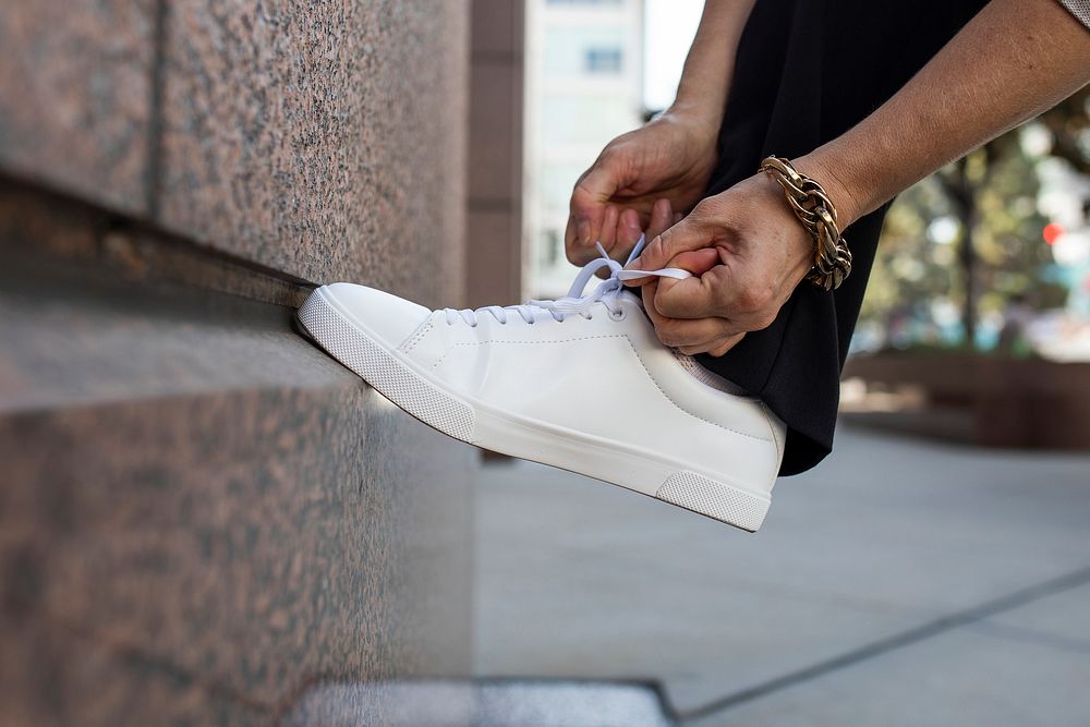 Canvas sneakers white model tying shoelaces apparel ad