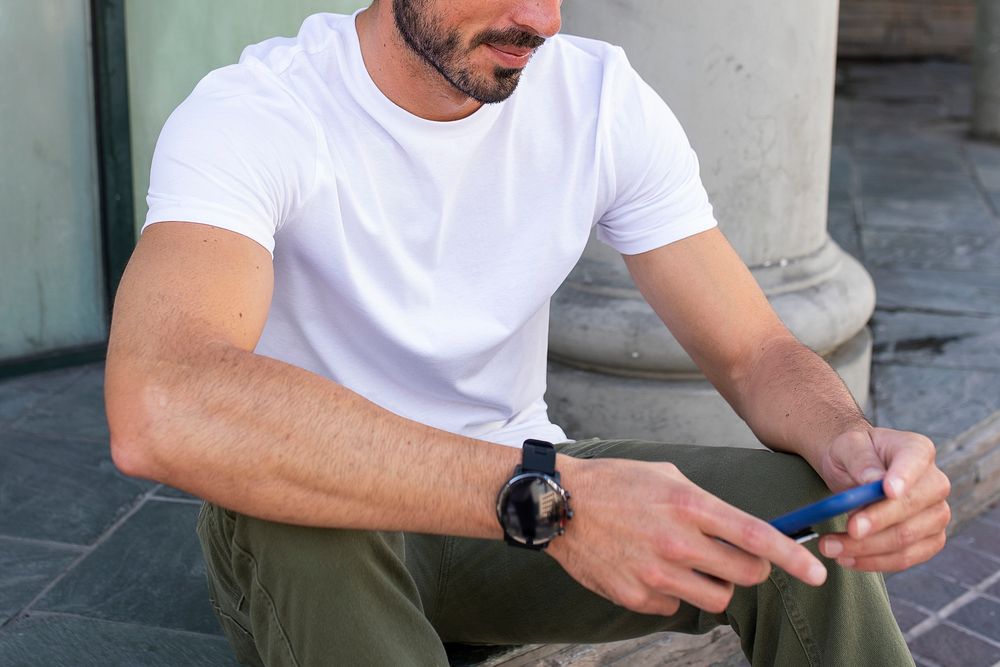 Casual dressed man playing with phone outdoor photoshoot