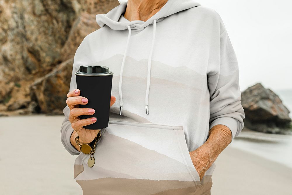 Senior woman holding travel coffee cup
