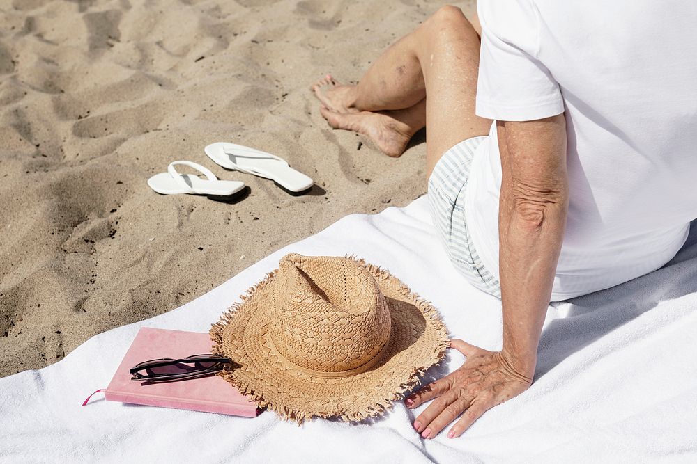 Beach essentials with senior woman relaxing on her vacation