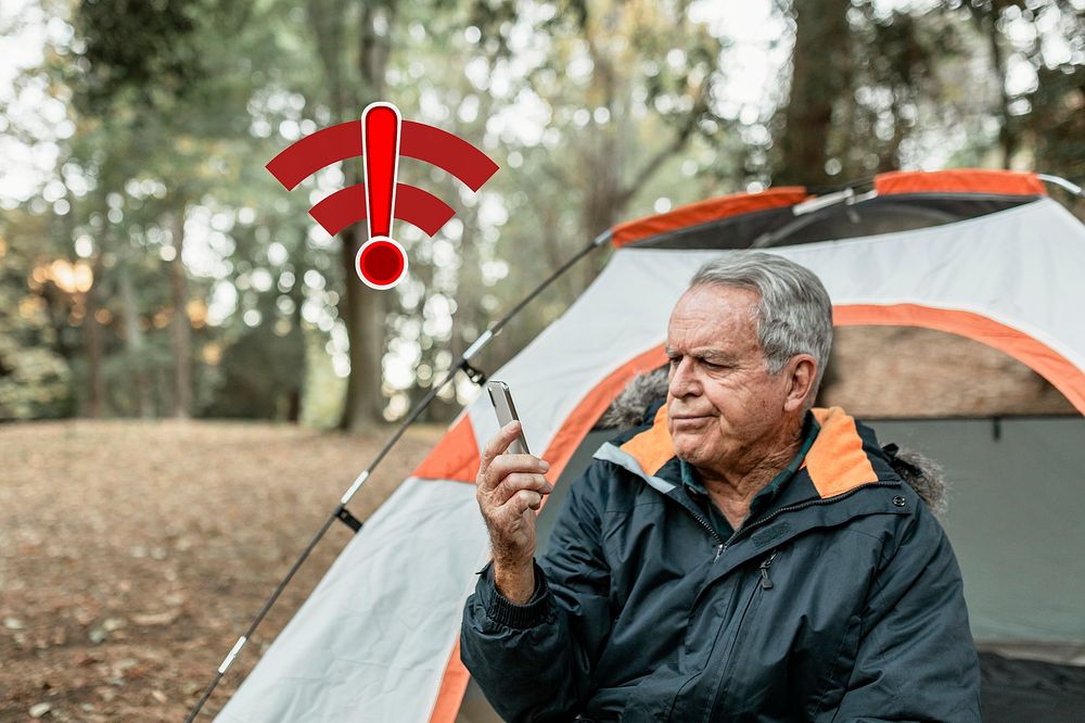 Elderly man searching for internet connection in the forest 