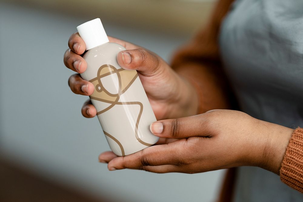Hand holding bottle, skincare product design
