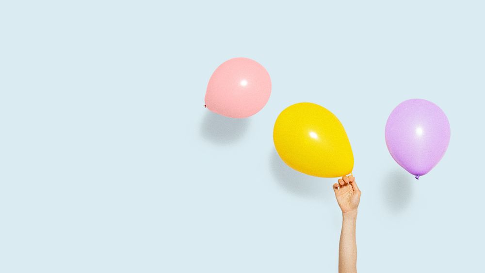 Hand holding a yellow balloon wallpaper