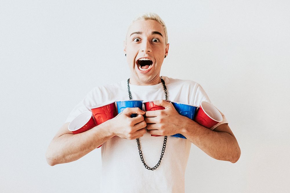 Cheerful young man holding cups