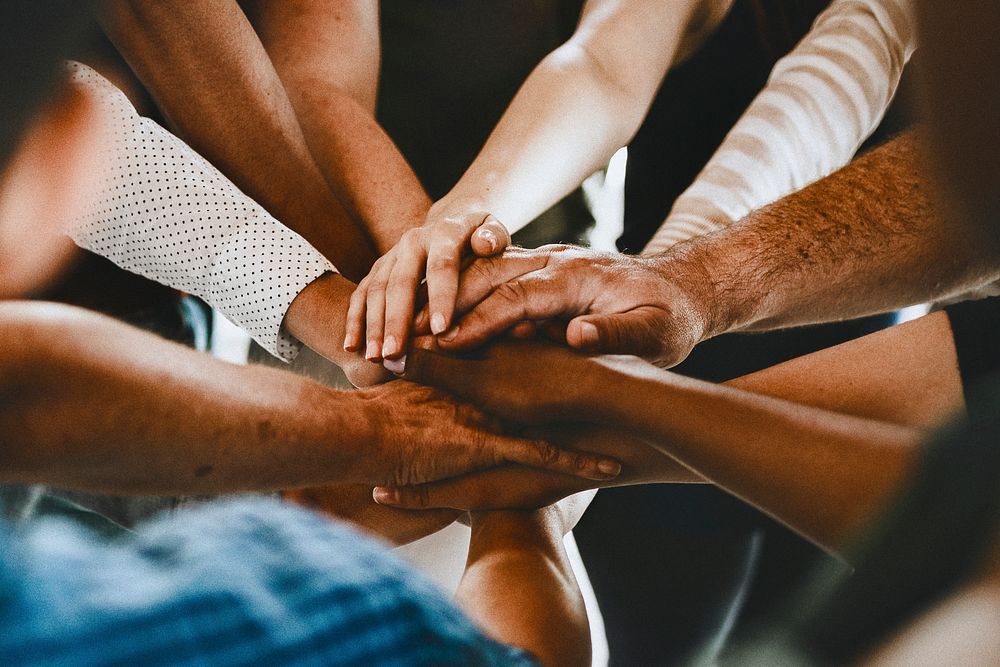 Group of diverse people stacking hands in the middle