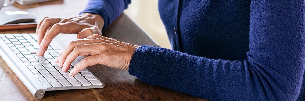 Senior woman typing on a computer keyboard