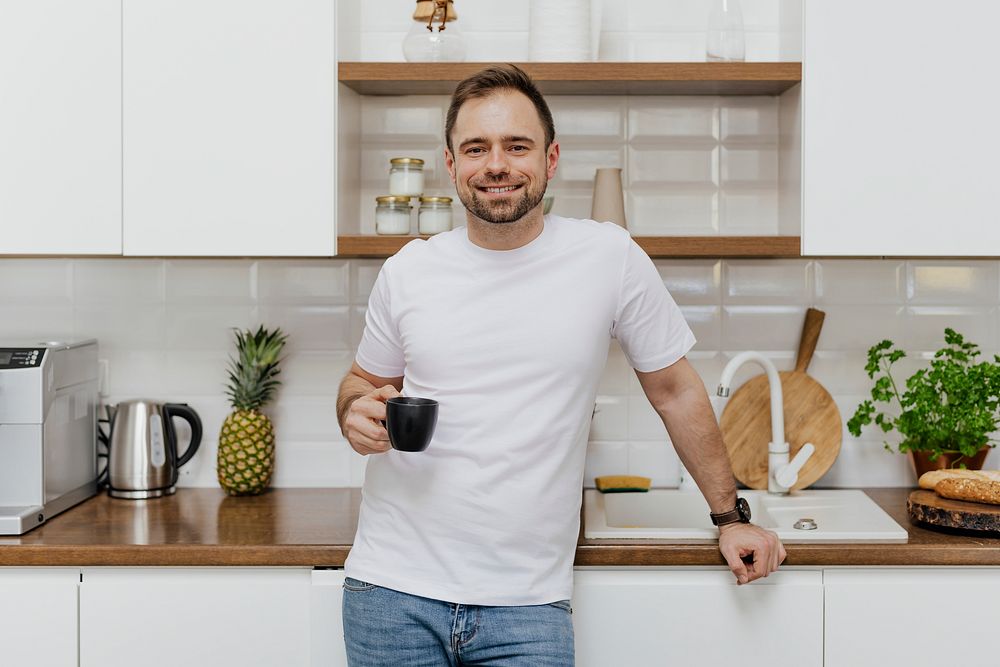 Happy man drinking coffee in the kitchen