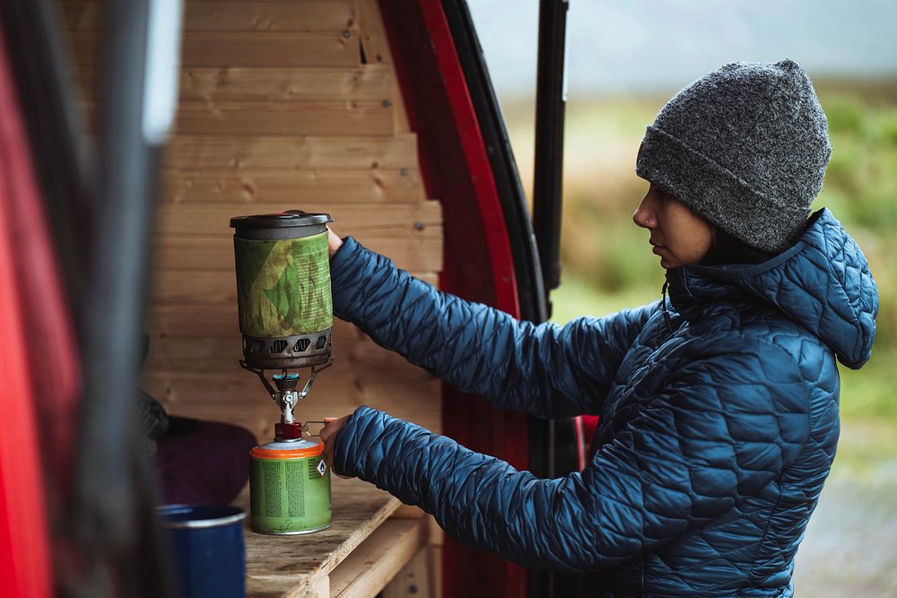 Woman using a portable camping stove to boil water