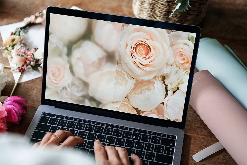 Florist creating designs on her laptop in a flower shop