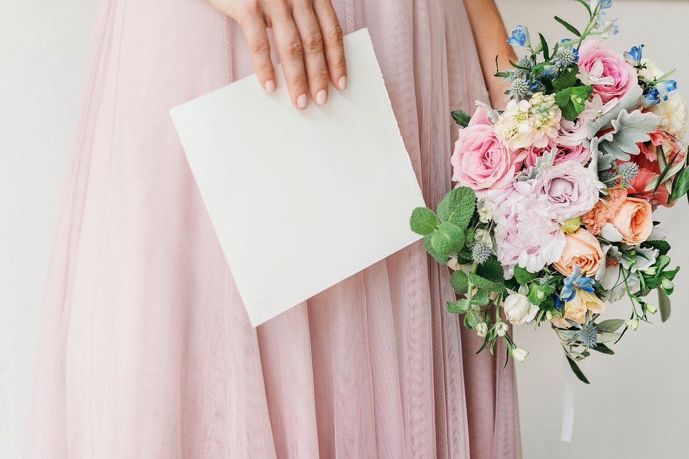Bride holding a card with a bouquet of flowers