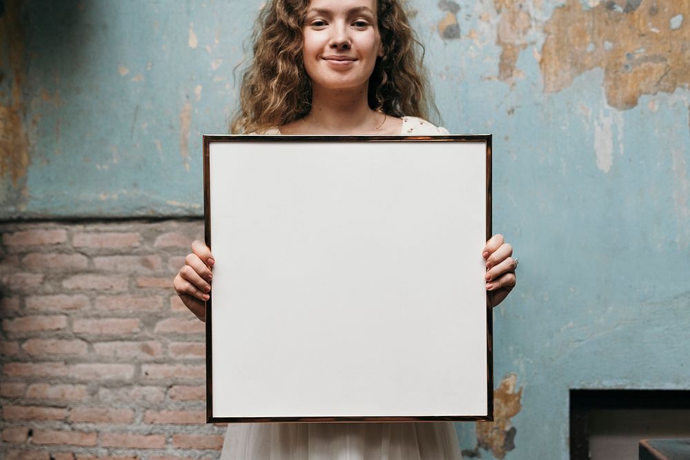 Cheerful woman holding a picture frame