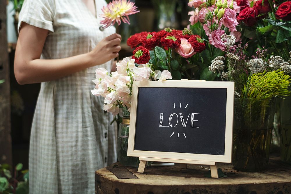 Florist standing by a love board