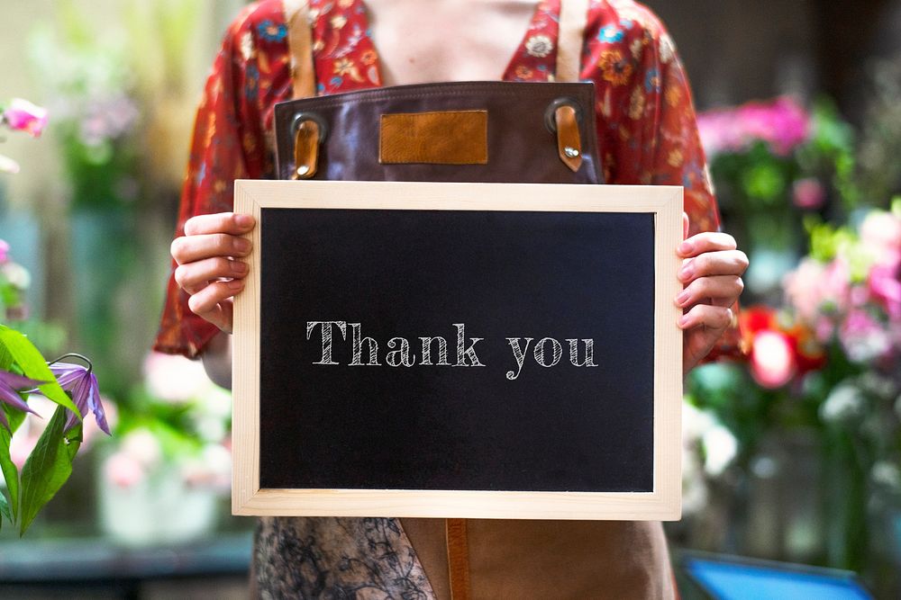 Florist holding a thank you board sign