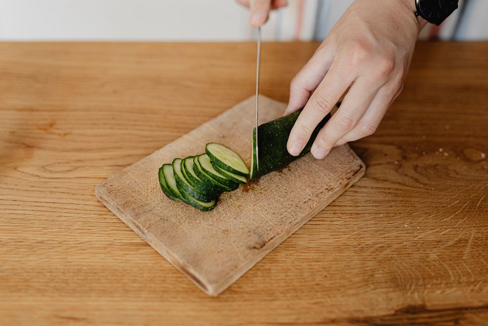 Woman slicing zucchini in the kitchen