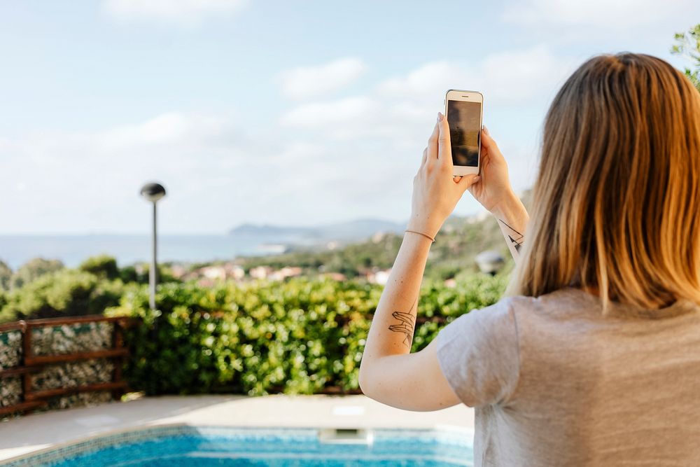 Woman taking a photo by the pool