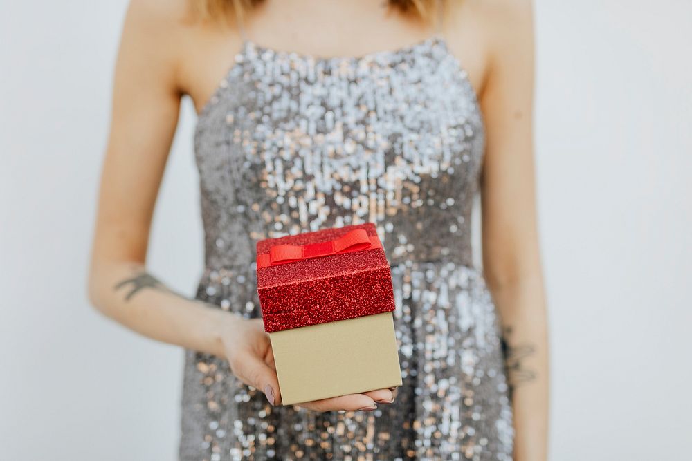 Woman in a silver dress holding gift boxes