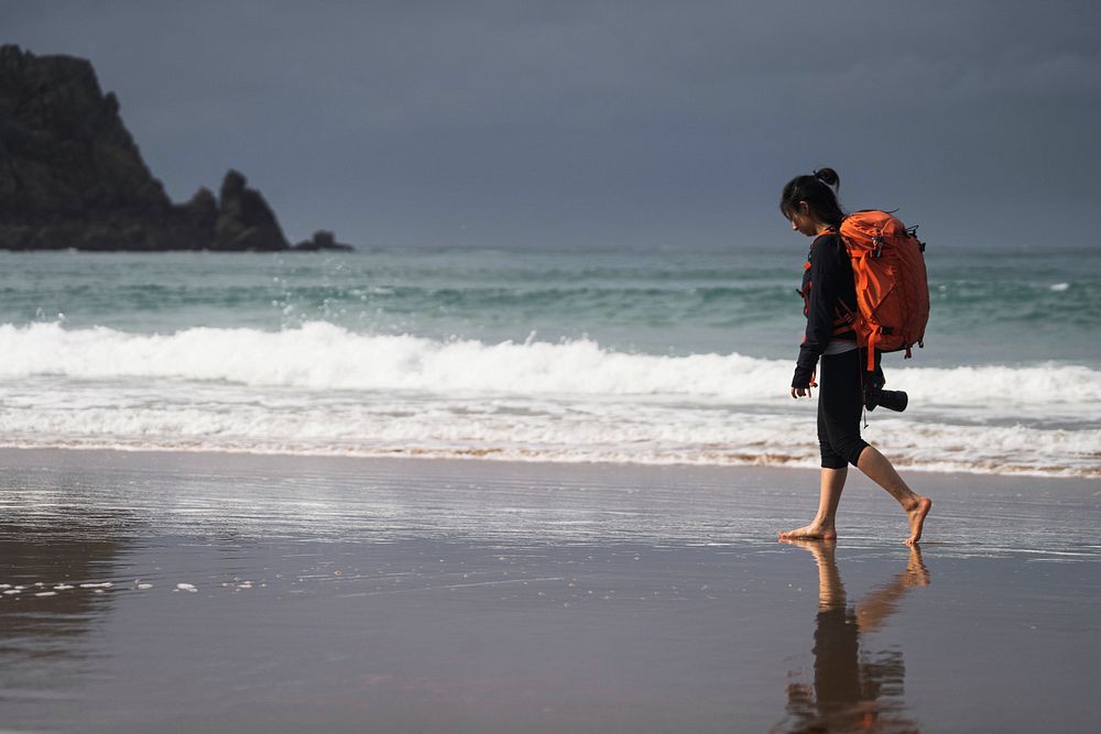 Female photographer walking along the beach