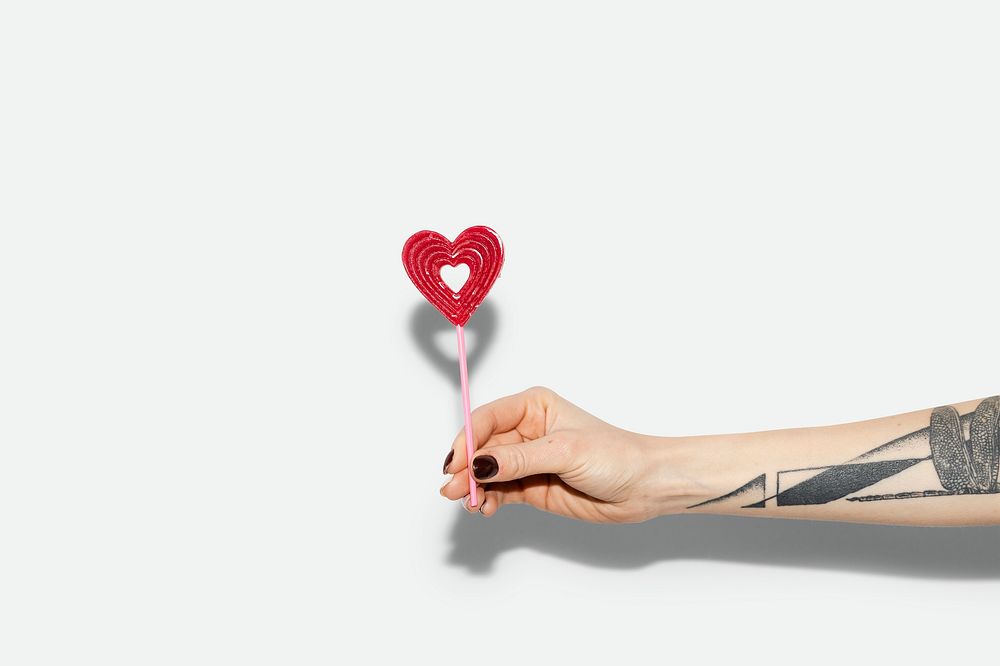 Woman holding a red heart on a stick