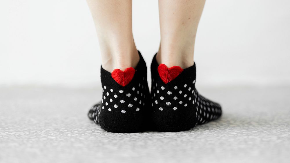 Woman wearing black socks with a red hearts wallpaper