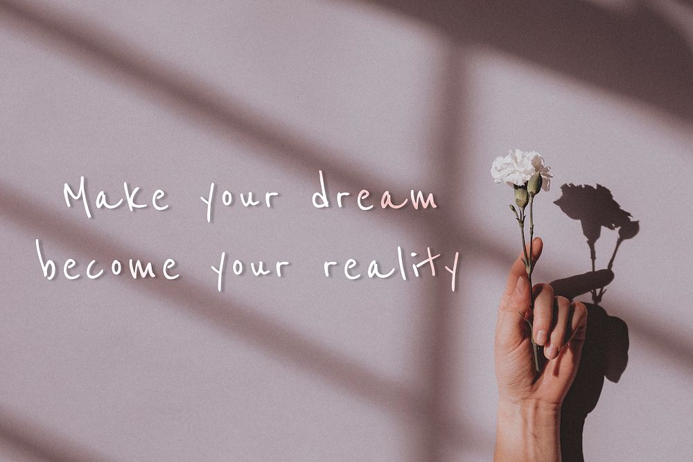 Make your dream become your reality quote on a hand holding flower background