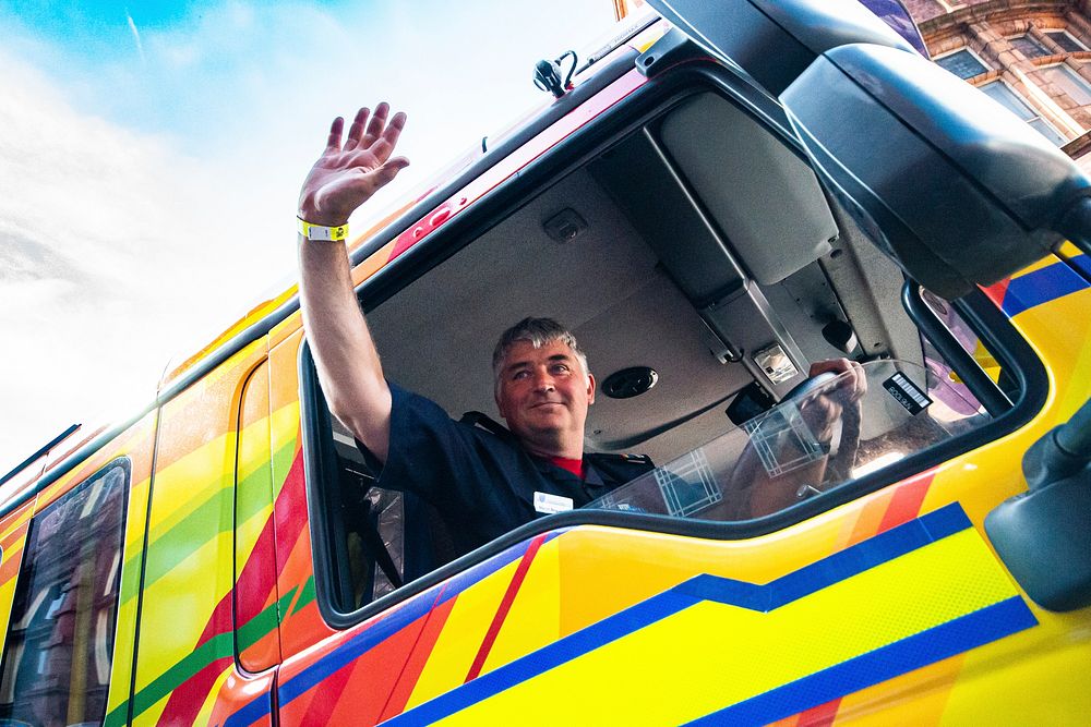 Man waving hand in a truck, August 24, 2019, Manchester, UK. Original public domain image from Flickr
