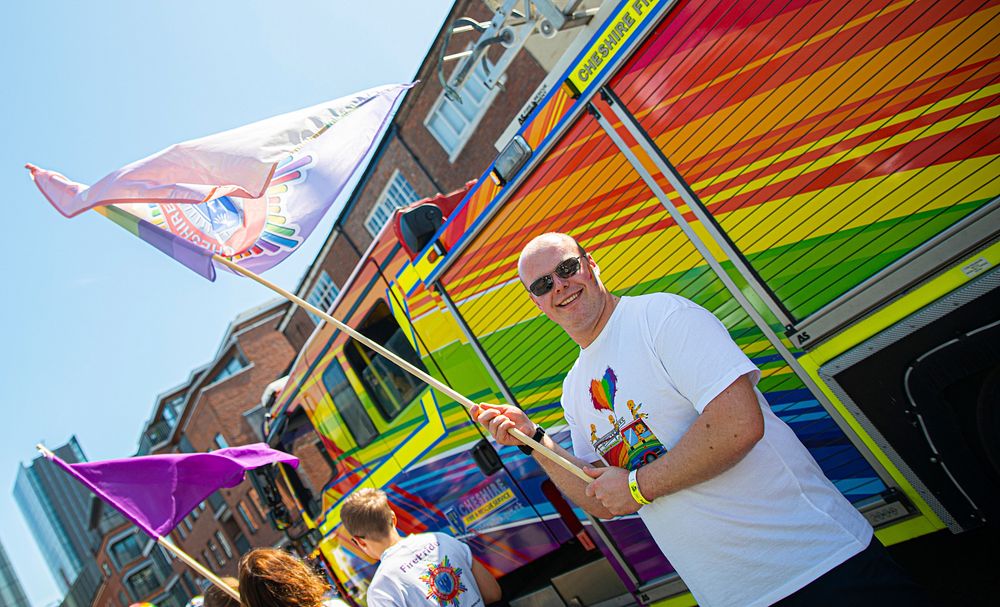 Man waving flag at pride parade, August 24, 2019, Manchester, UK. Original public domain image from Flickr